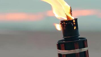 Tropical Bamboo Torch Burning in the Beach at Summer Evening. Decorative Candle Has a Massive Orange Flame Using Oil Fuel or Kerosene - Slow Motion. CloseUp Static Shot video