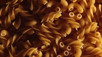 Uncooked Fusilli and Chifferi Rigati Pasta - Top View, Close-Up, Low Key Light. Fat and Unhealthy Food. Classic Dry Macaroni, Rotating Background. Raw Different Macaroni Pasta Texture - Rotate Right video