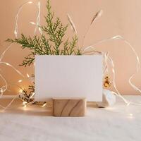 Blank white greeting card mockup in a Christmas scene. Warm and cozy aesthetic christmas scene background with a blank paper with copy space. photo