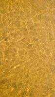 Vertical abstract background. Golden river water surface with sun reflections photo