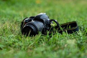 digital camera on green grass with bokeh photo