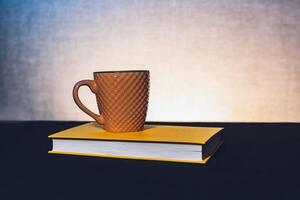 Mug with a book the theme of learning or creating a postcard photo