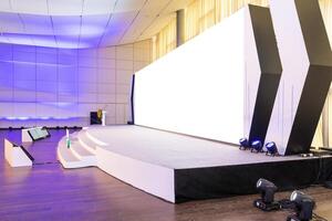 Empty conference hall with empty white projector screen photo