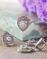 Silver ring and earrings with zirconia sparkling on the table photo