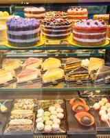Display of delicious cakes and pastries tempting customers in bakery shop window photo