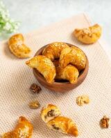 Homemade croissants filled with walnut paste sprinkled with sesame seeds photo