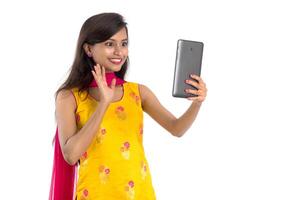 Young Indian girl using a Tablet, mobile phone or smartphone isolated on a white background photo