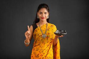Young girl holding and posing with kitchen utensils on a grey background photo