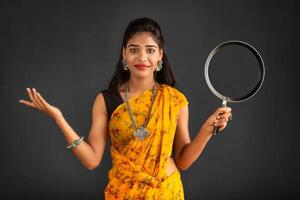 Young girl holding and posing with kitchen utensils pan on a grey background photo
