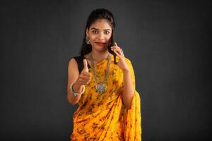 Young beautiful girl or woman holding and using smartphone or mobile or tablet phone on a grey background photo
