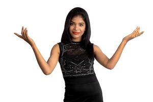 Portrait of a successful cheerful young girl pointing and presenting something with hand or finger with a happy smiling face. photo