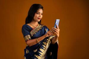 Young beautiful girl or woman holding and using smartphone or mobile or tablet phone photo