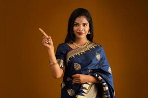 Portrait of a cheerful young girl or woman pointing something with a happy smiling face. photo