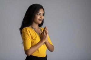 Beautiful Indian girl with welcome expression or inviting or greeting Namaste photo