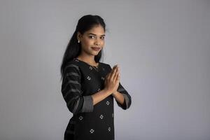 Beautiful Indian girl with welcome expression or inviting or greeting Namaste photo