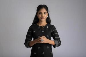 Portrait of a young beautiful cute cheerful girl smiling looking at the camera on gray background photo