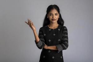 Beautiful girl holding and presenting something in the hand with a happy smiling face. photo