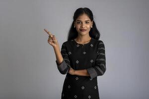 Beautiful girl holding and presenting something in the hand with a happy smiling face. photo