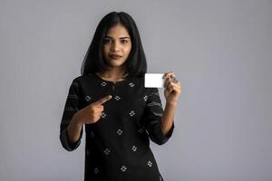 Young smiling beautiful woman or girl presenting credit card in hand showing trust and confidence for making payment. photo