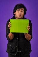 Young happy man holding and posing with the book on background. photo