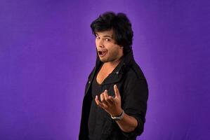 Young handsome man over dark background afraid and shocked with surprise and amazed expression, fear and excited face. photo