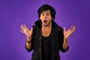 Young handsome man over dark background afraid and shocked with surprise and amazed expression, fear and excited face. photo