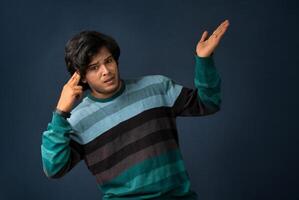 Portrait of a successful cheerful young man holding and presenting something on hand with a happy smiling face. photo