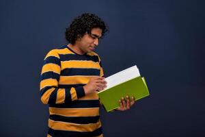Young happy man holding and posing with the book on gray background. photo