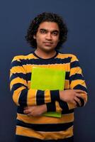 Young happy man holding and posing with the book on gray background. photo
