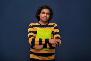 Young happy man holding and posing with the book on gray background. photo