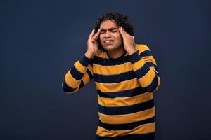 Portrait of young man stress or having the pain of a headache on a grey background. photo