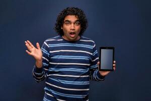 Young handsome young man, businessman showing a blank screen of smartphone or mobile or tablet phone on grey background photo