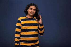 Young handsome young man holding and using smartphone or mobile or tablet phone on grey background photo