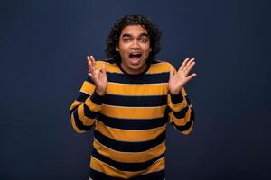 Young handsome man over gray background afraid and shocked with surprise and amazed expression, fear and excited face. photo