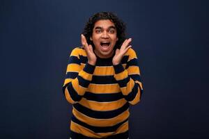 Young handsome man over gray background afraid and shocked with surprise and amazed expression, fear and excited face. photo