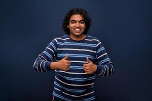 Portrait of a successful cheerful young man pointing and presenting ok, victory sign with hand or finger with a happy smiling face. photo