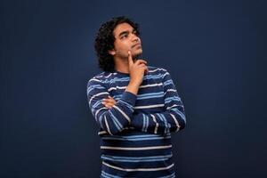 Portrait of a young man thinking on a dark background photo