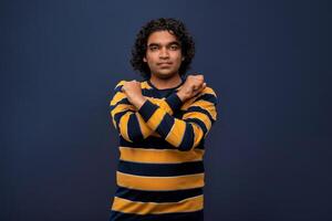 Portrait of a man crossing hands and showing palm, stop gesture, warning of end finish, forbidden way. indoor studio shot on gray background photo