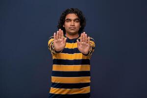 Portrait of a man crossing hands and showing palm, stop gesture, warning of end finish, forbidden way. indoor studio shot on gray background photo