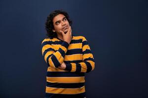 Portrait of a young man thinking on a dark background photo