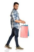 Young handsome man holding and posing with shopping bags on a white background photo