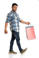 Young handsome man holding and posing with shopping bags on a white background photo