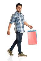 Young handsome man holding and posing with shopping bags on a white background photo