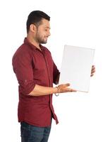 A happy young man holding and displaying a signboard or placard in his hands on a white background. photo