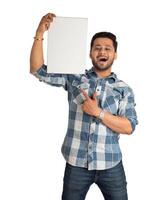 A happy young man holding and displaying a signboard or placard in his hands on a white background. photo