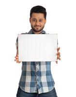 A happy young man holding and displaying a signboard or placard in his hands on a white background. photo
