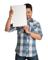 A happy young man holding and displaying a signboard or placard in his hands on a white background. photo
