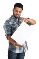 A happy young man holding and displaying a signboard or placard in his hands on a white background. photo