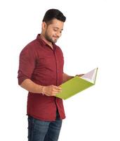 Young happy man holding and posing with the book on white background. photo