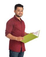 Young happy man holding and posing with the book on white background. photo